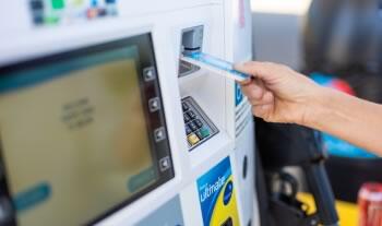 woman inserting credit card on the gasoline dispenser