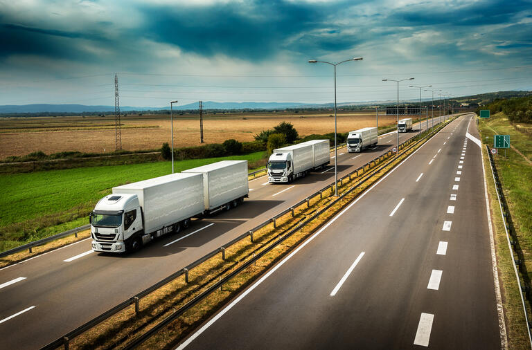 Caravan or convoy of White Lorry trucks in line on a country highway