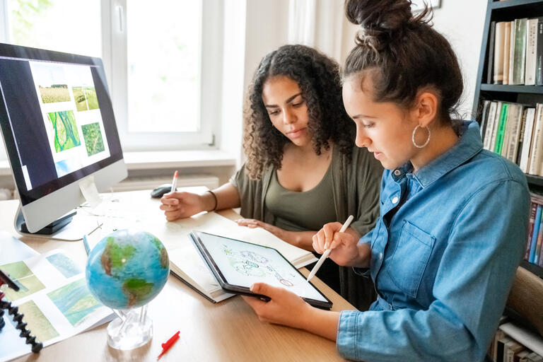 2 woman looking at some plans