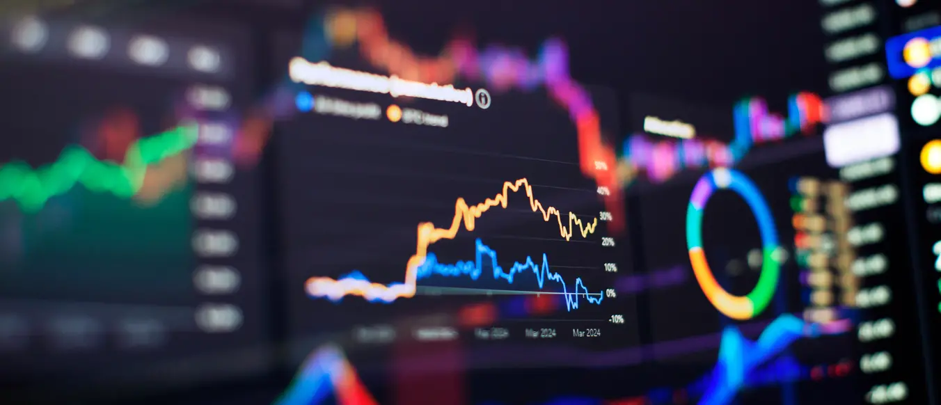 brightly colored graph lines on multiple computer screens