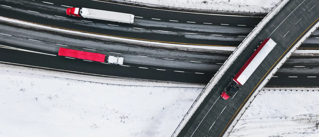 icy road and overpass with three trucks