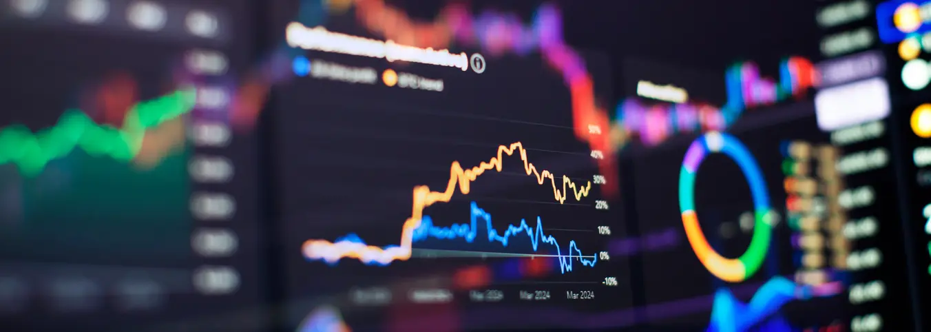 brightly colored graph lines on multiple computer screens