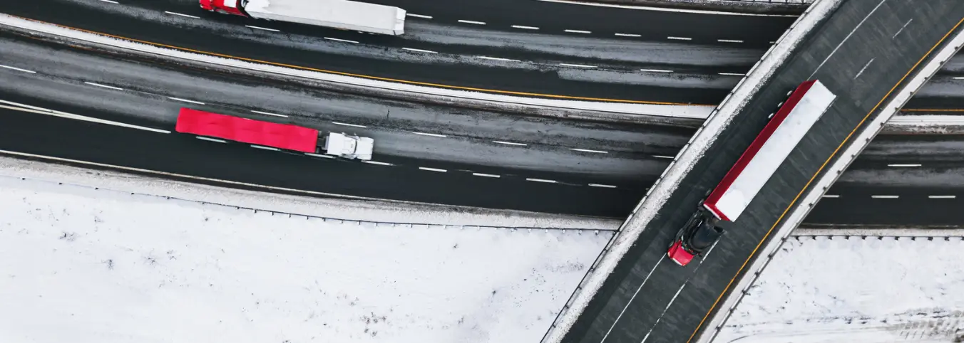 icy road and overpass with three trucks