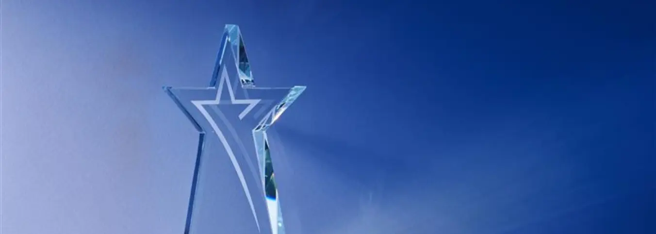 Clear, star-shaped trophy in front of a faded blue background