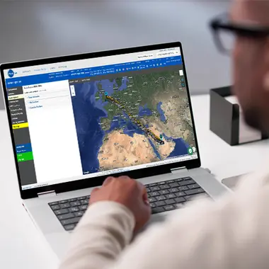 man sitting at desk viewing flight planner functionality