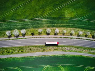 Drone shot direct above a truck moves along a single road.