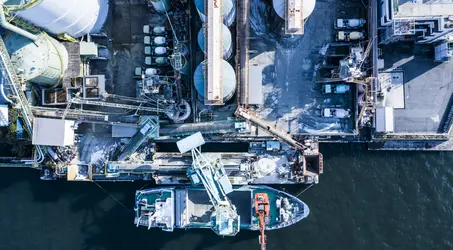 Vessel at shore fueling port with fuel storage silos