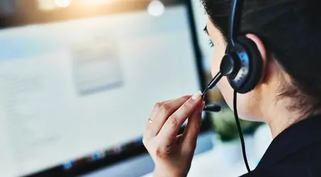 person looking at a computer with a headset on