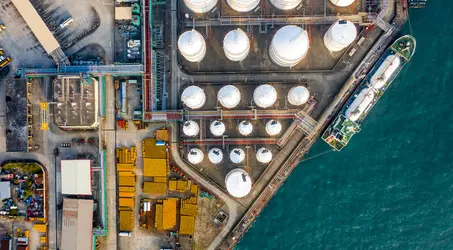 overhead shot of marine tanker next to fuel storage tanks