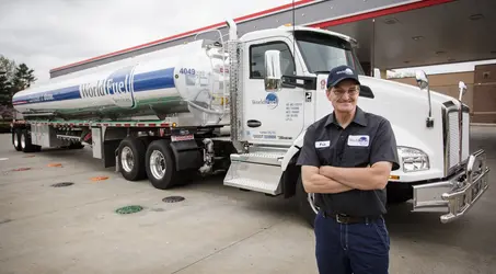 truck driver standing in front of a pump
