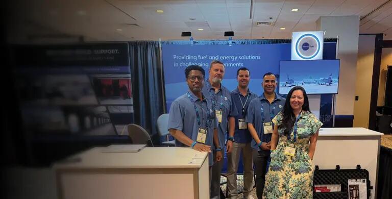 Employees in front of tradeshow booth