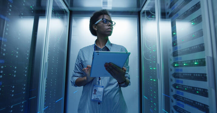 PErson walking through server room with tablet