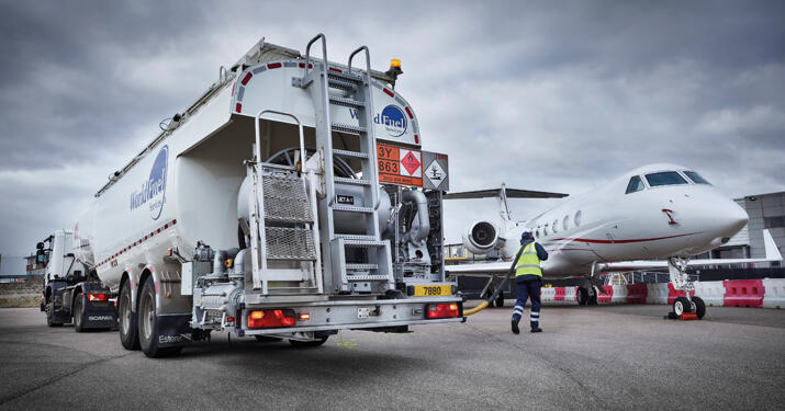 World Fuel Services fuel truck pulled up next to a jet, ready to fill it with jet fuel