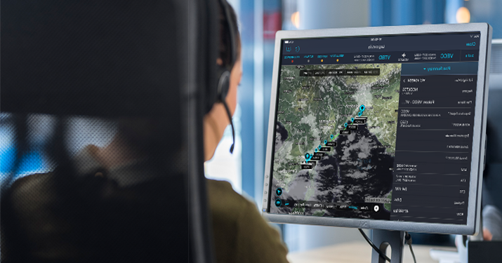 woman with headset viewing trip plan on computer