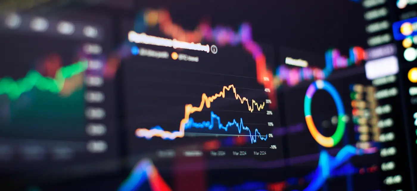 brightly colored graph lines on multiple computer screens